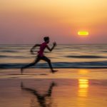 man running along seashore during golden hour
