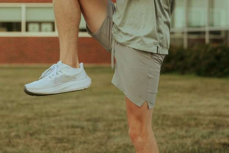 a man sitting on a skateboard on a sidewalk